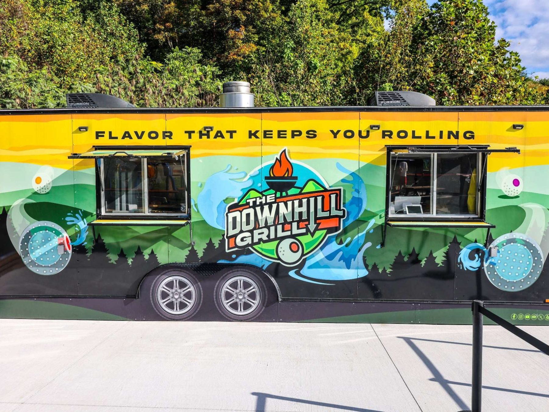 Colorful food truck with 'The Downhill Grille' logo and slogan.